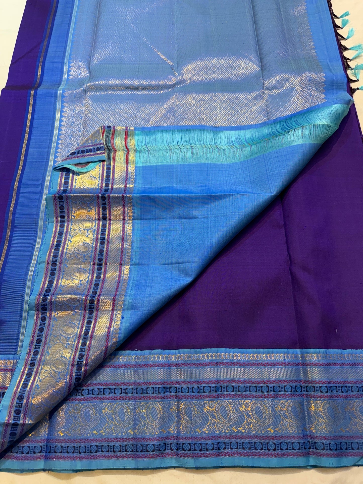 Turquoise blue Korvai border detail on a royal purple Kancheepuram saree