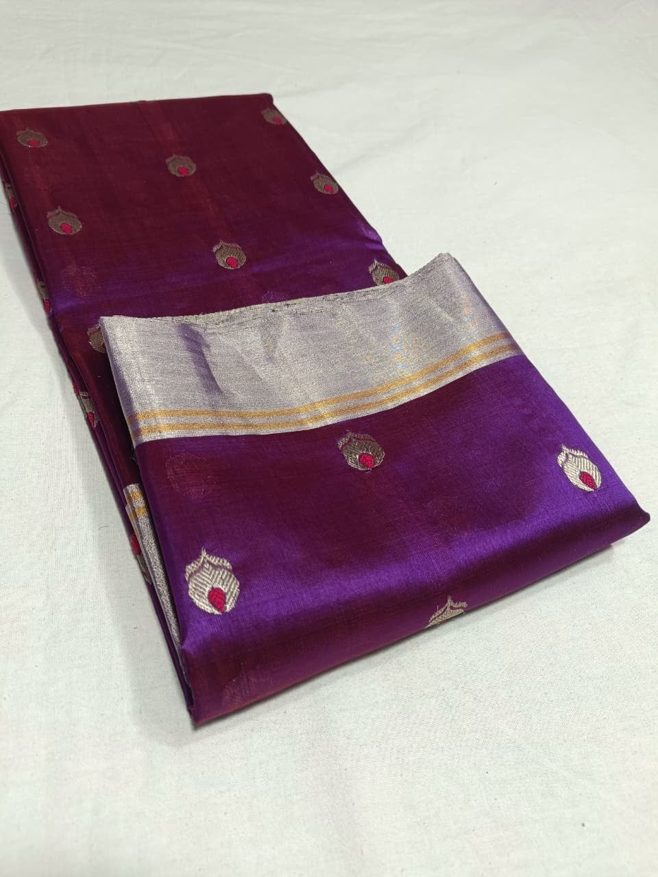 Royal Purple Pattu Silk Chanderi saree folded to show metallic buttas with Rani Pink centres and lustrous silk texture