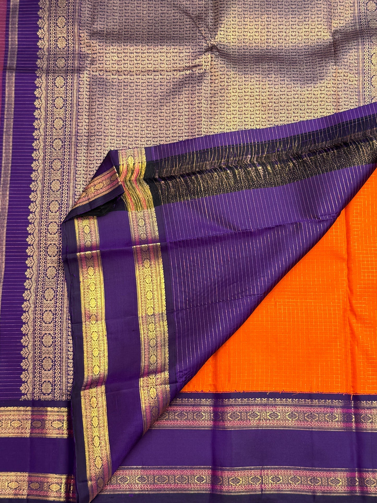 Royal purple Rettapet gold zari border detail on orange Kanchipuram silk saree