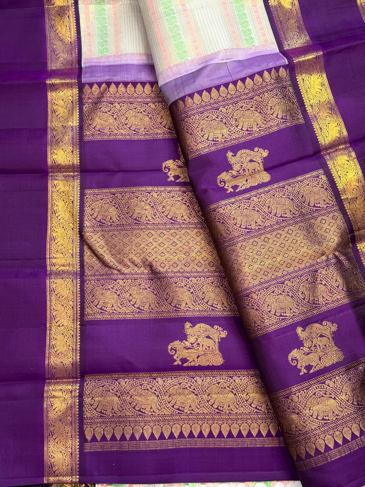 Royal purple Rettapet border with gold zari Yaanai motifs in floral framing on a Kanchipuram silk saree