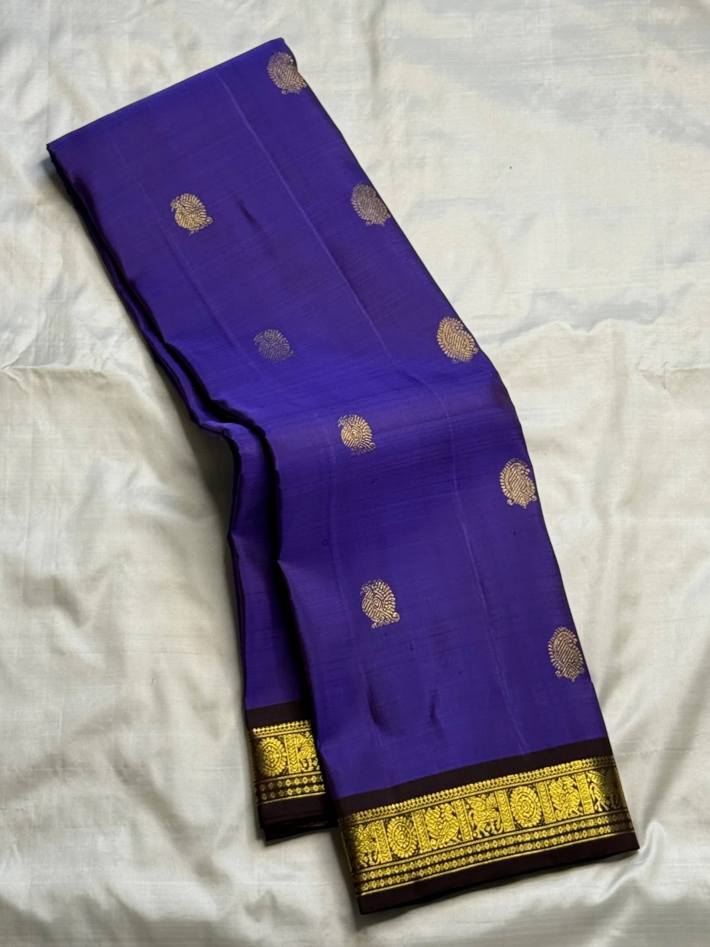 Close view of antique-gold zari buttas woven on Royal Violet Kanjivaram silk.