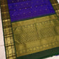 Royal-violet pure silk Kanchipuram saree folded to show petite gold buttas and bottle-green Sorgavaasal Mayil border with circular ornamental frames.