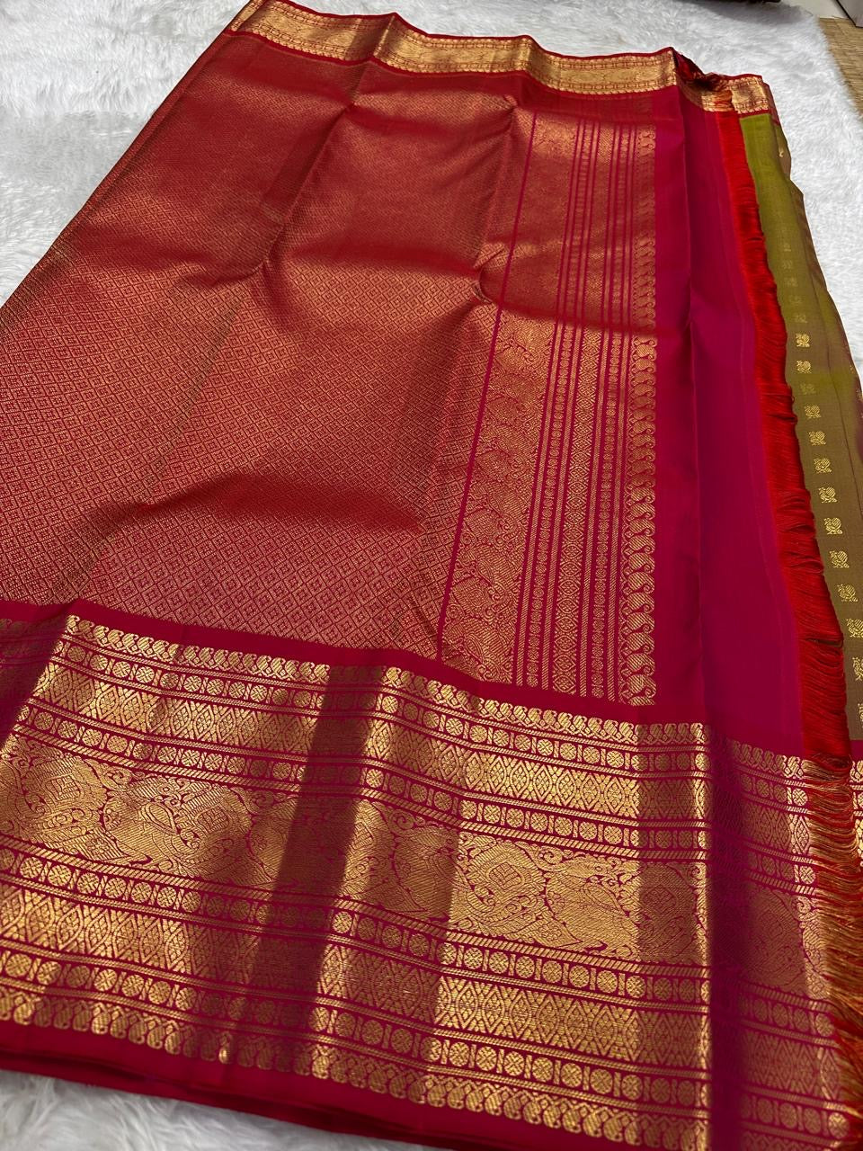 Ruby-pink border showing three stacked gold zari registers separated by fine framing lines.