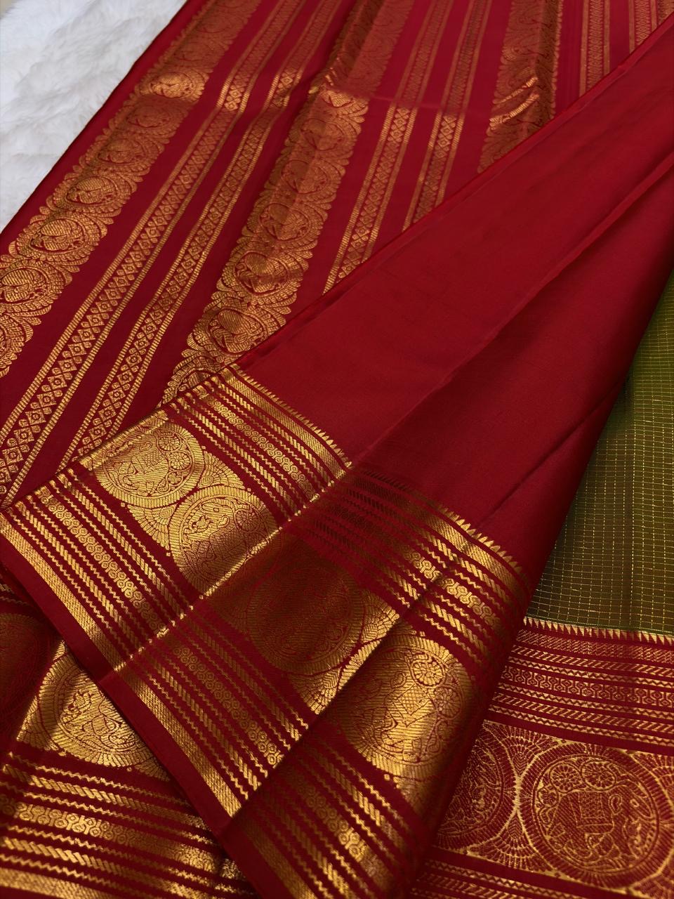 Rich ruby red border with bold circular zari medallions on a green silk saree