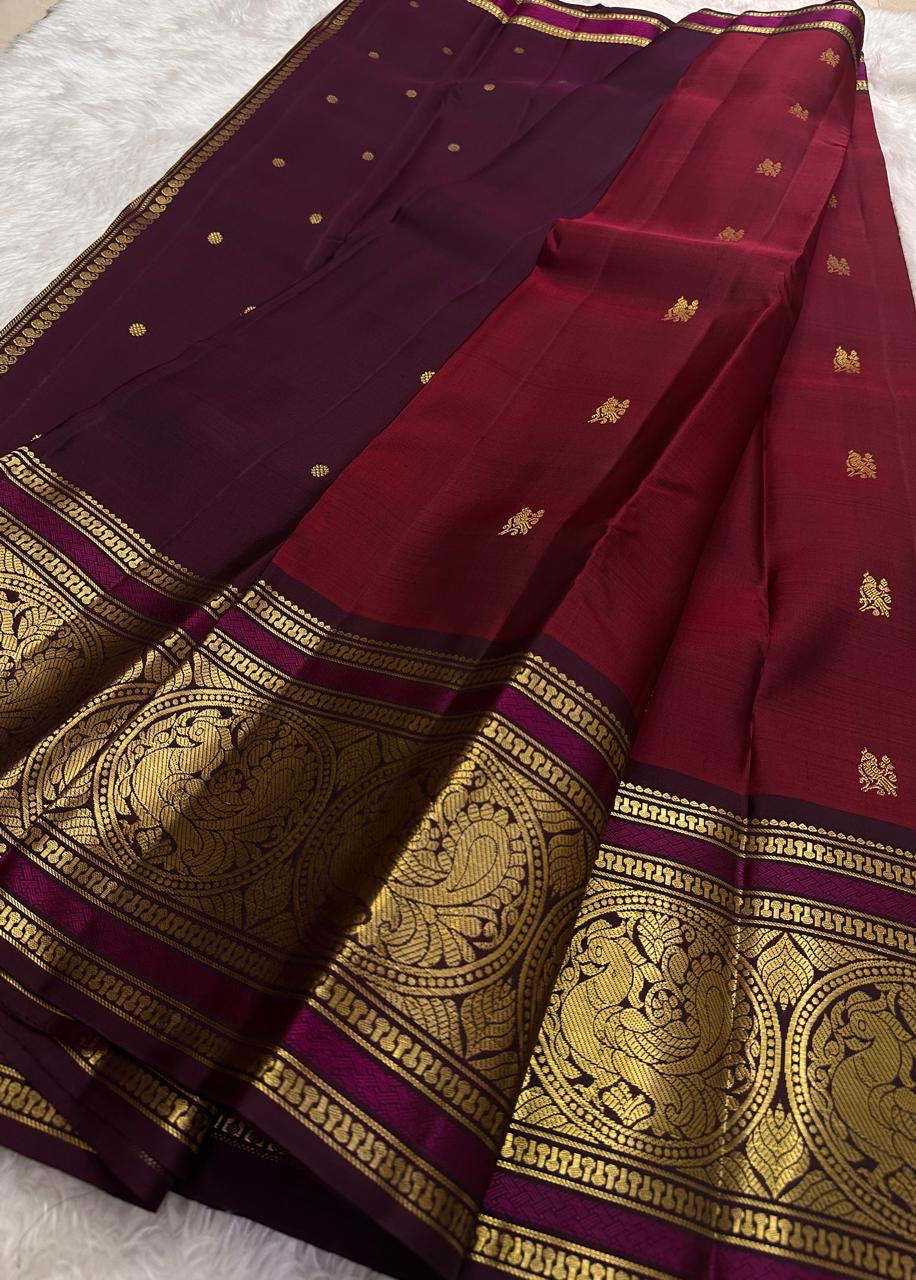 Ruby red Kanchipattu silk saree with sorgavaasal mayil peacock motif detail