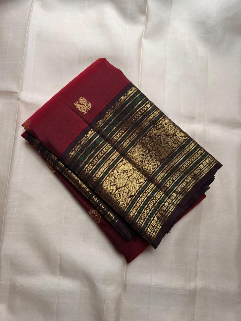 Ruby red pure silk Kanjeevaram saree with deep brown border and teal zari accents