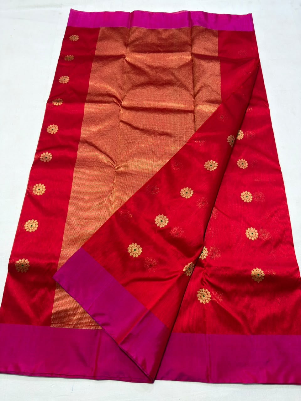 Broad copper-gold-toned woven pallu on a red and pink Chanderi handloom saree.