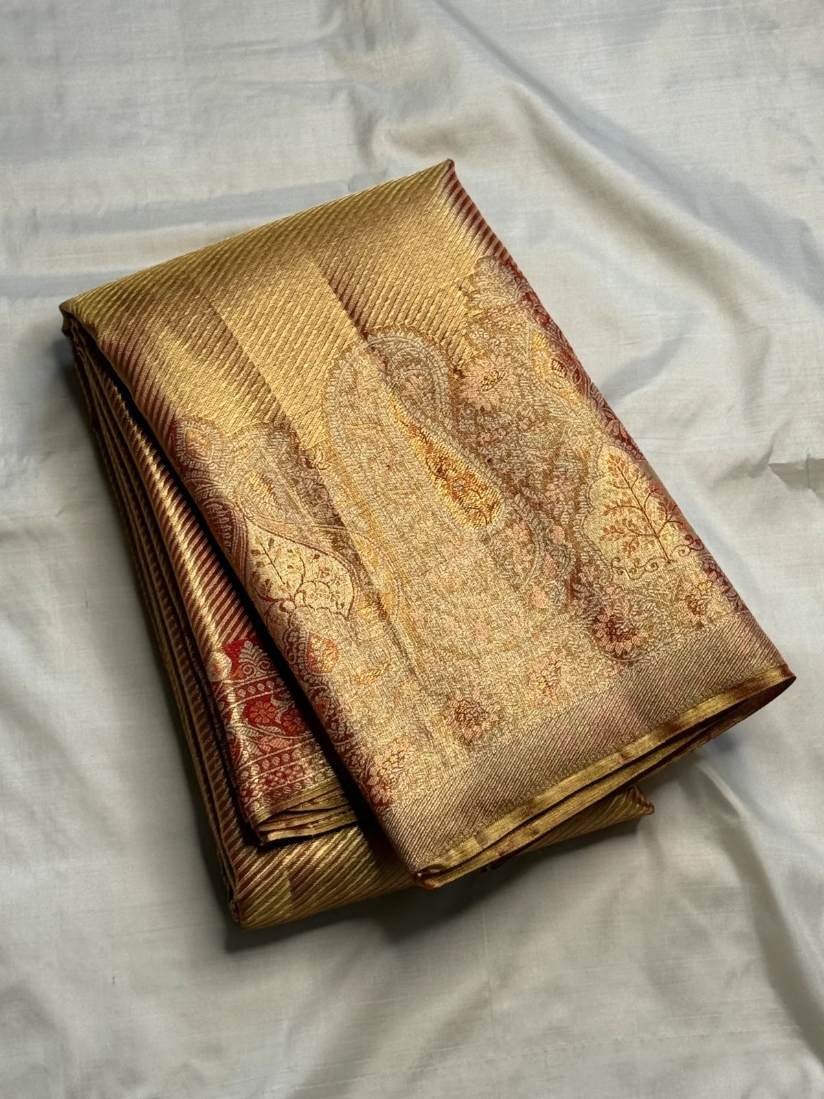 Rust Gold Kanchipuram silk saree with continuous fine diagonal antique-gold zari ribbing.