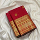 Stacked traditional Kanchipuram border in layered gold zari bands on a kumkum red silk saree