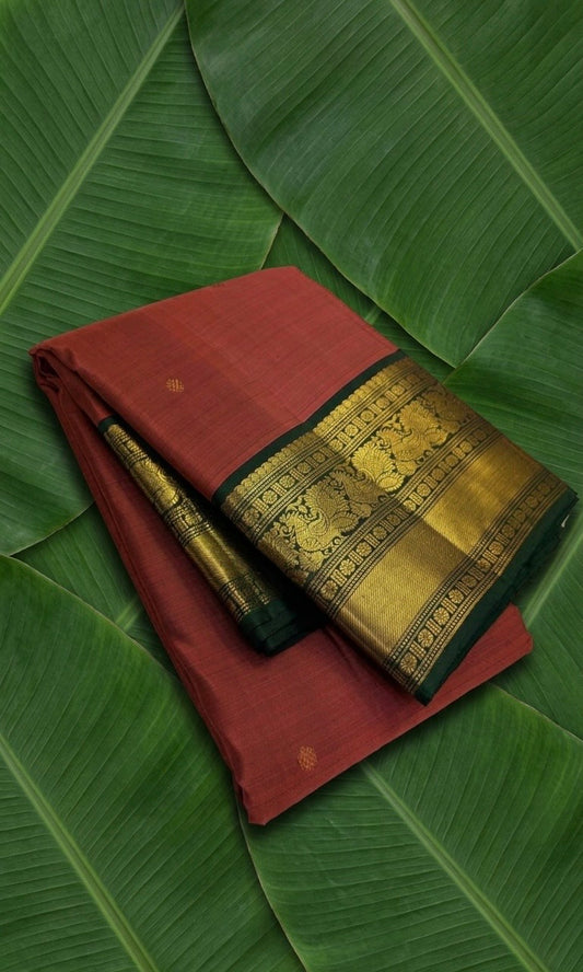 Rust orange Kanchipuram silk saree with gold zari korvai and deep forest green border