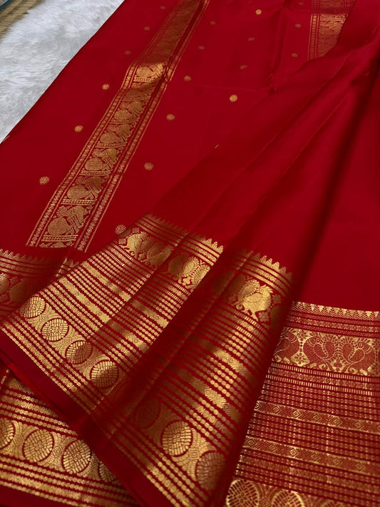 Rust orange Kanjipuram silk saree body close-up showing Vairaoosi-style rich diagonal zari stripe bands across the pure mulberry silk