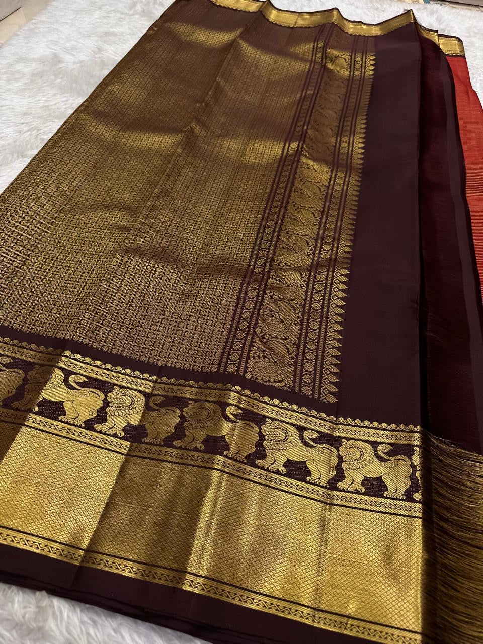 Rust red Kanchi Pattu saree — deep aubergine border and pallu detail