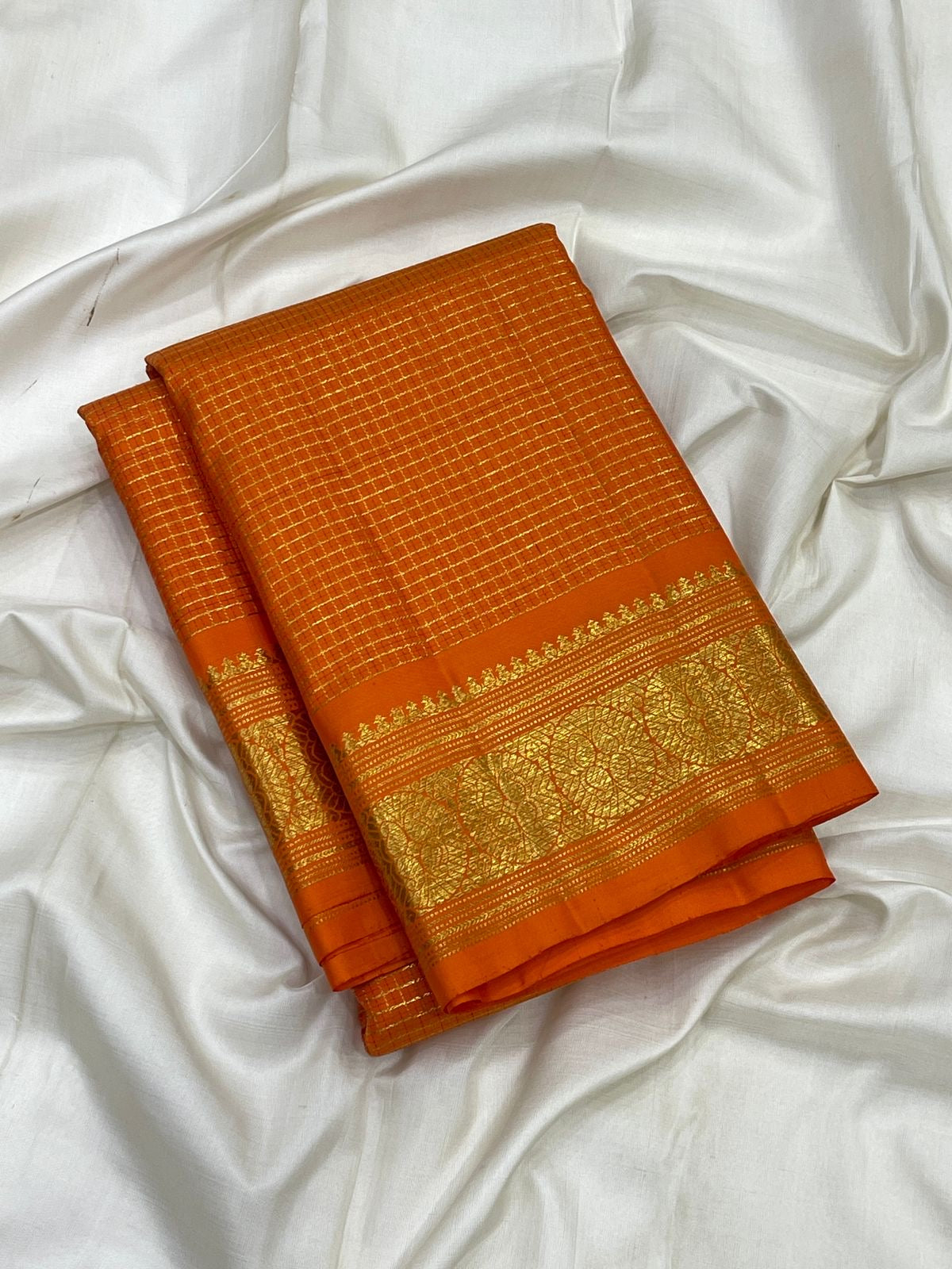Broad floral gold zari border on Saffron Orange Zari Kattam silk saree.