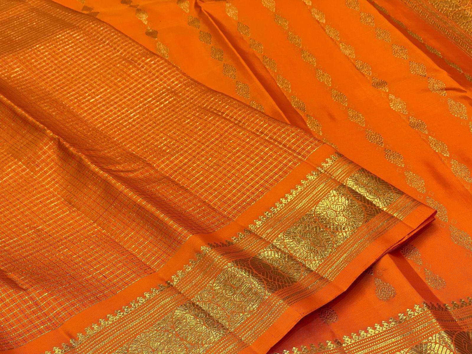 Saffron Orange Kanchipuram silk woven with fine intersecting gold Zari Kattam checks.