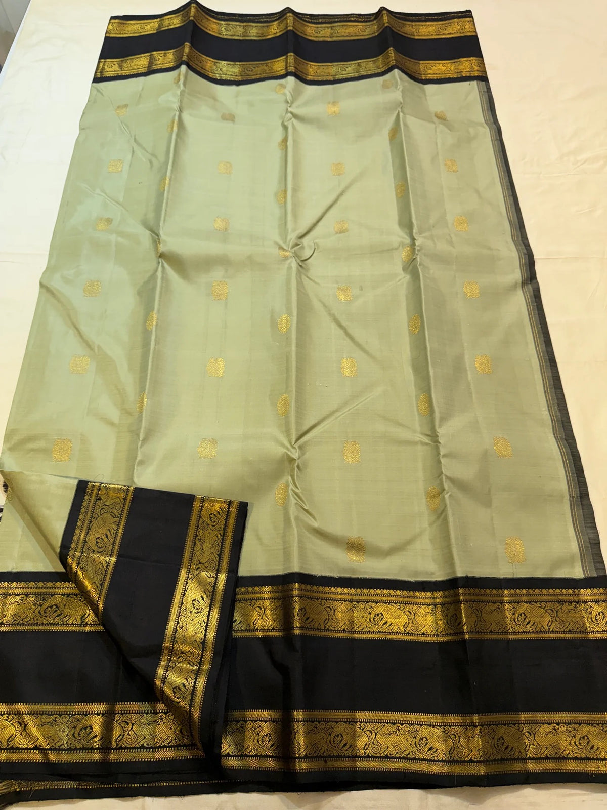 Detail of the ink blue contrast border on the sage green Kanchipuram saree