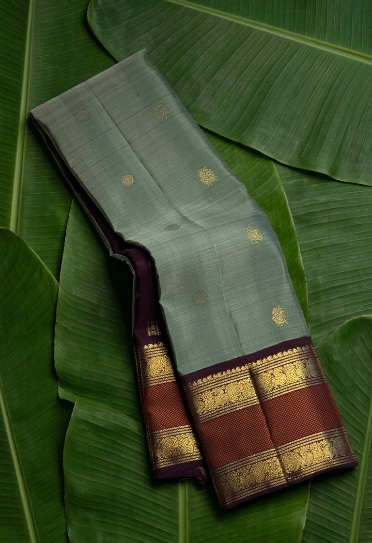 Sage green handwoven Kanchipuram pure silk saree with mayil chakram butta and coffee brown korvai rettapet border — Idam Living