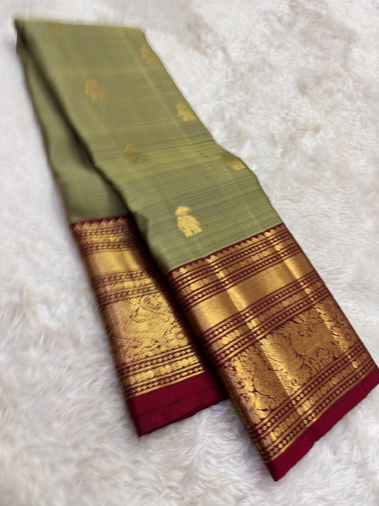 Handwoven sage green Kanjipuram pure silk saree with gold zari Yaanai Ambari Butta and deep red Vanasringaram border