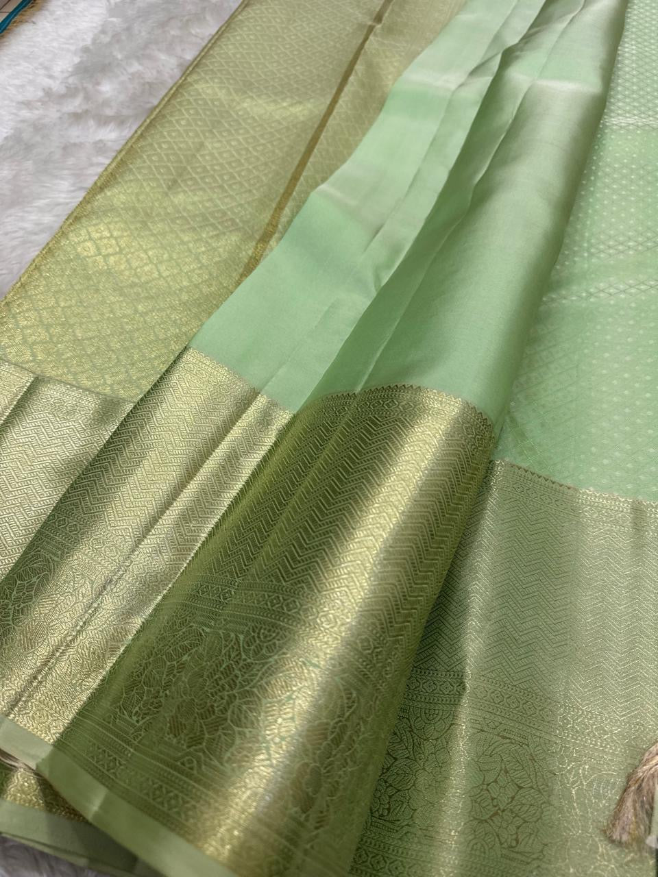 Gold zari border detail on sage green Kanjivaram saree