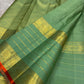 Muted green Kanchipuram silk saree with small spaced antique-gold zari buttas.