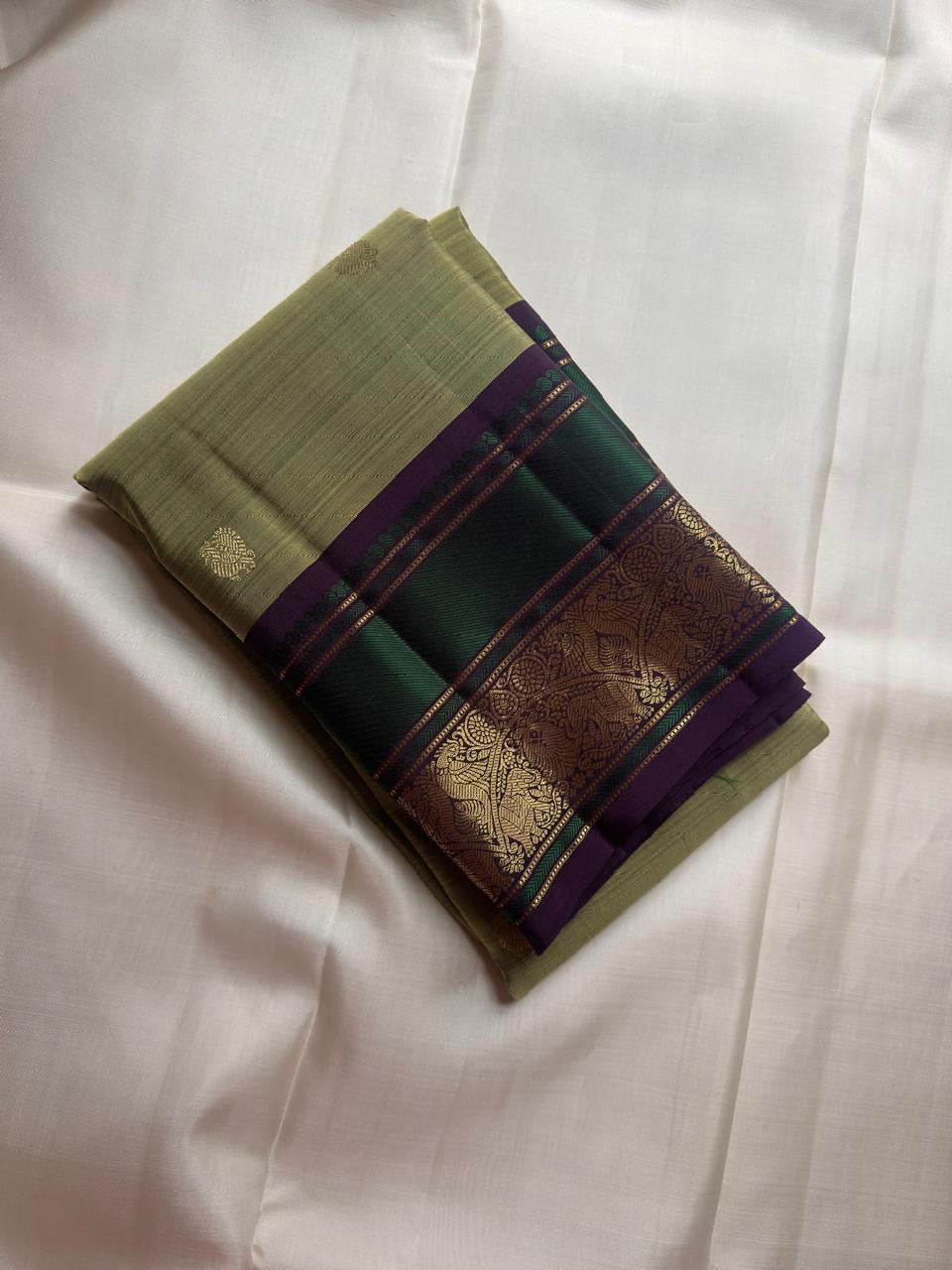 Close-up of antique gold zari Butta motifs on sage olive green KanchiPattu silk saree