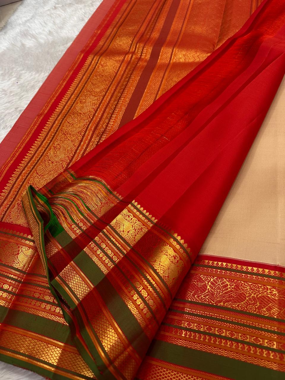 Red and green pallu with full Varisaipet array in antique gold zari cascading across width