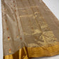 Draped Sandalwood Beige handloom Chanderi saree showing petite gold buttas with red accents and luminous floral woven pallu.