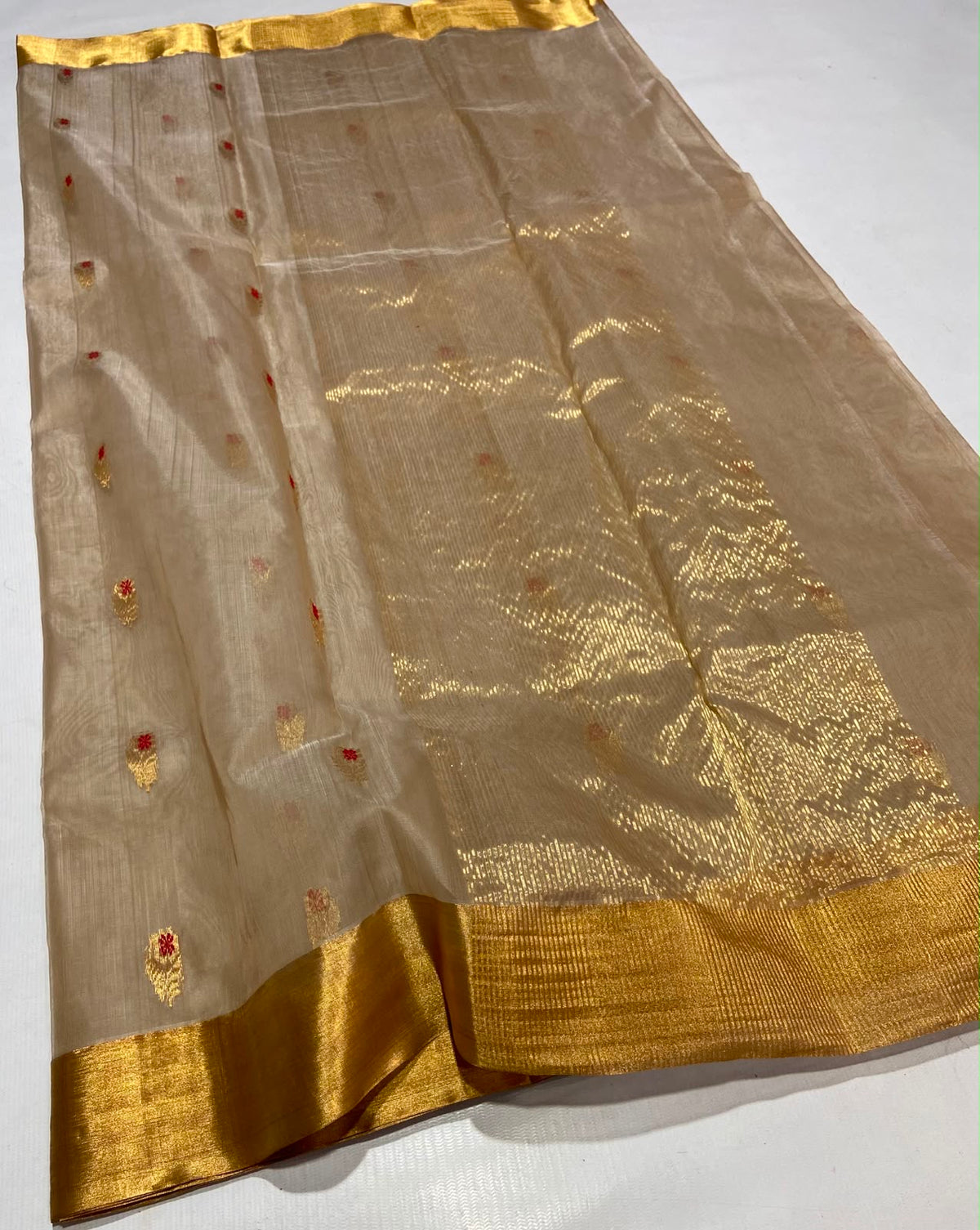 Draped Sandalwood Beige handloom Chanderi saree showing petite gold buttas with red accents and luminous floral woven pallu.
