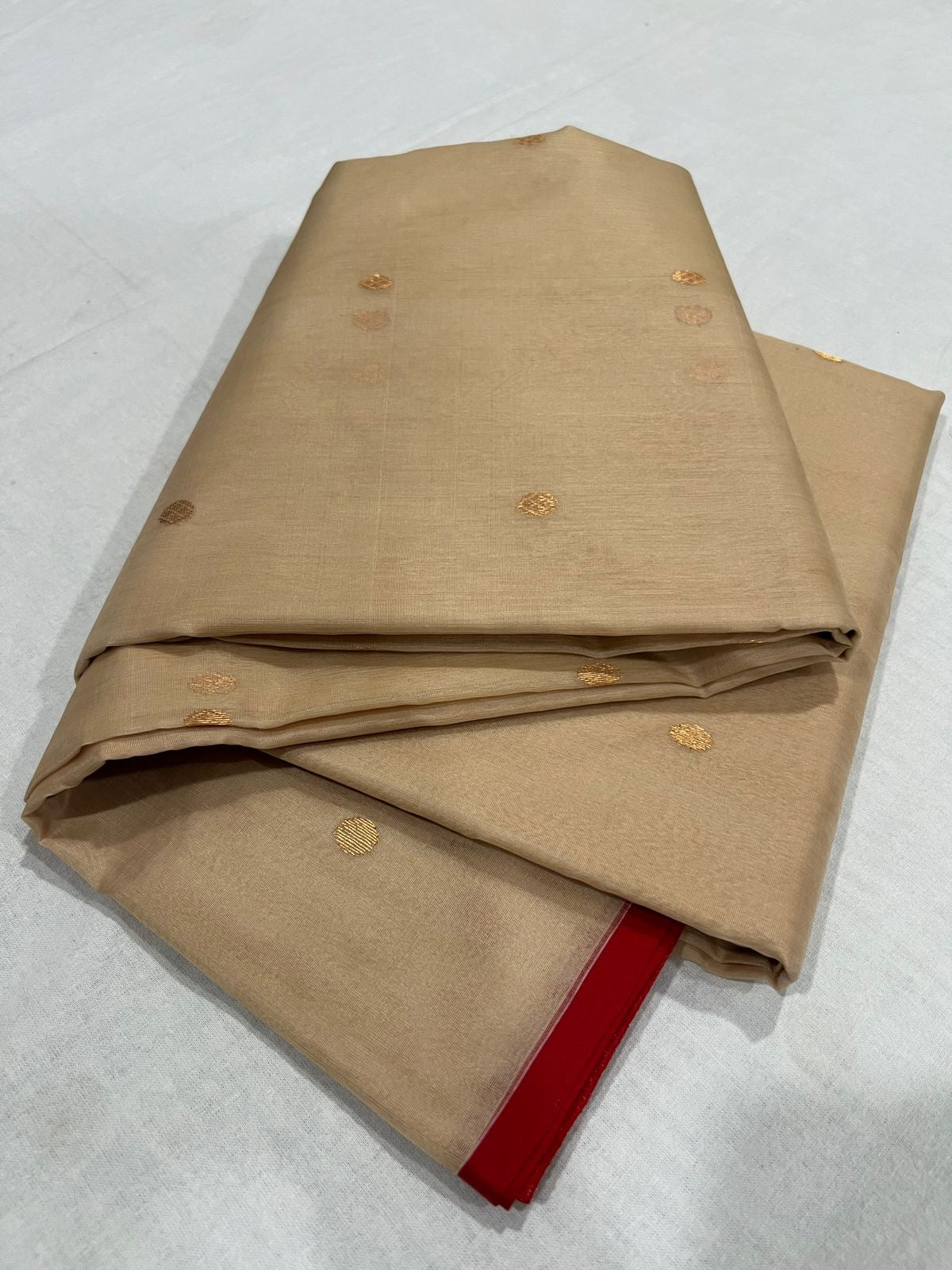 Folded Sandalwood Beige Chanderi Katan Silk saree with spaced gold-toned woven buttas and red border