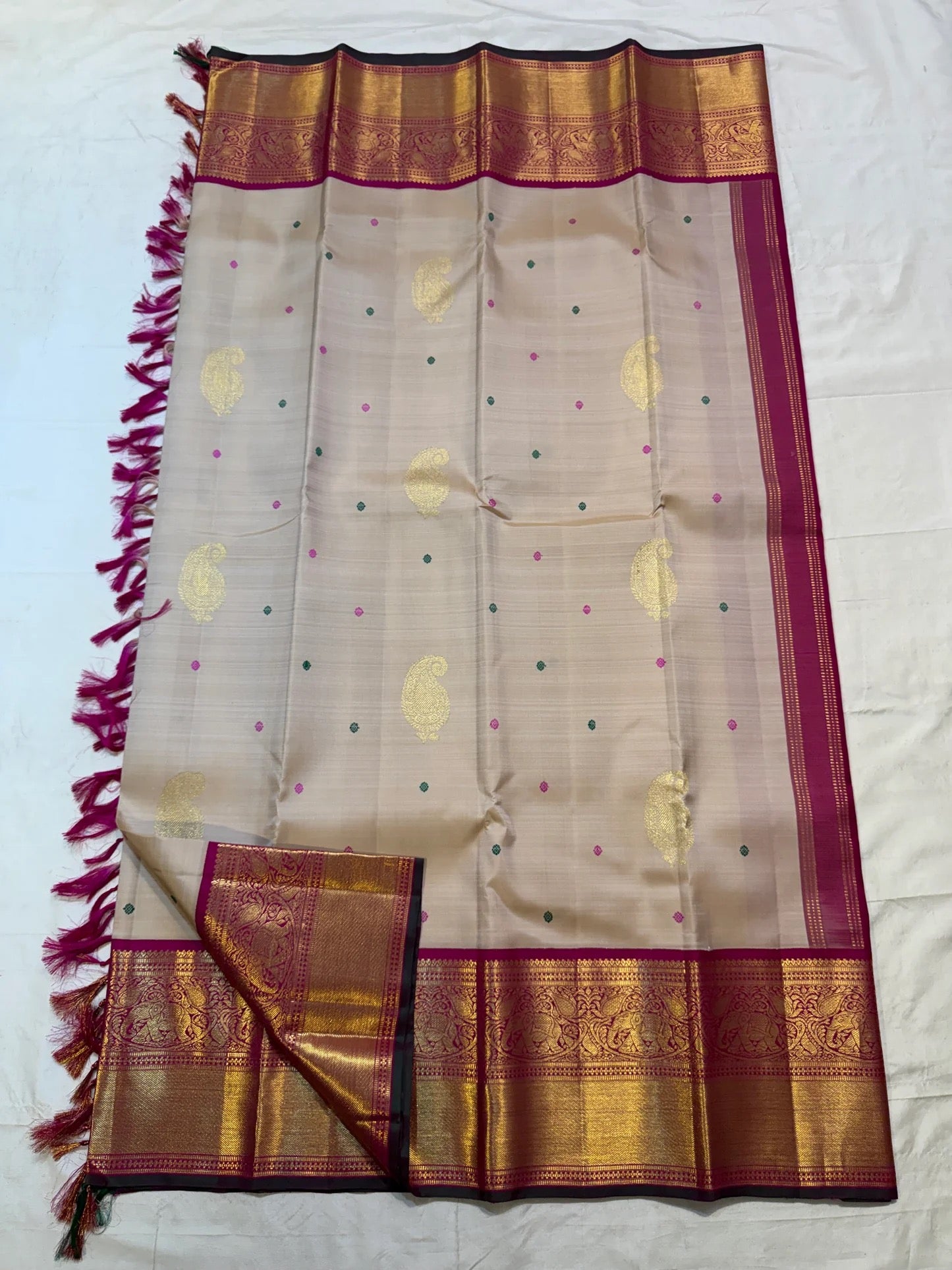 Close folded view of the Sandalwood Beige body and broad Deep Magenta zari border with elephant panels