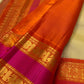 Ivory Chandanam Kanchipuram silk body with petite zari maanga buttas and radiant orange Rettapet border.