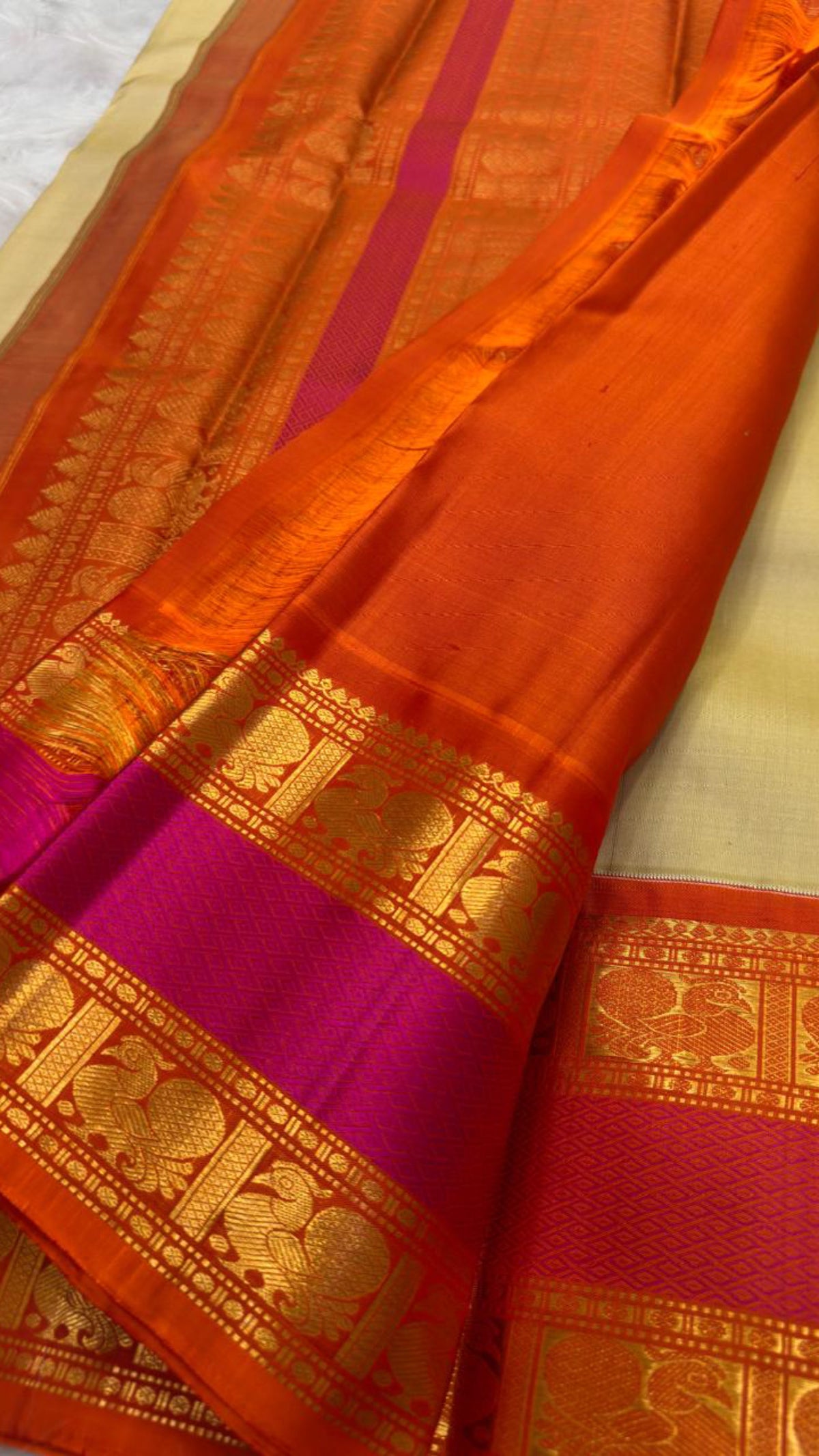 Ivory Chandanam Kanchipuram silk body with petite zari maanga buttas and radiant orange Rettapet border.