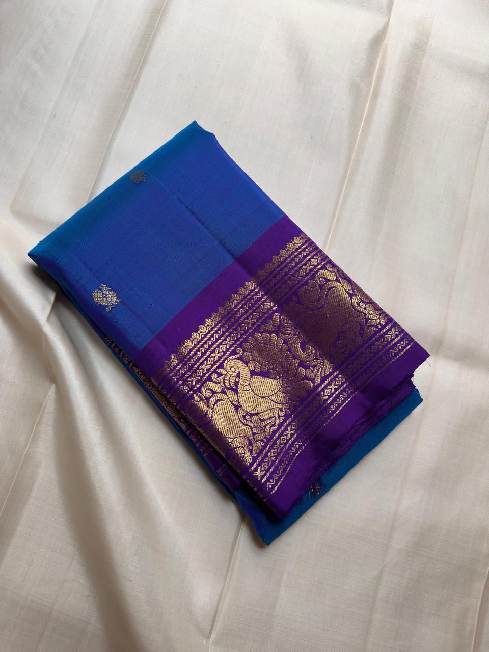 Brilliant Sapphire Blue Kanchipuram body scattered with small traditional classic-gold zari buttas.