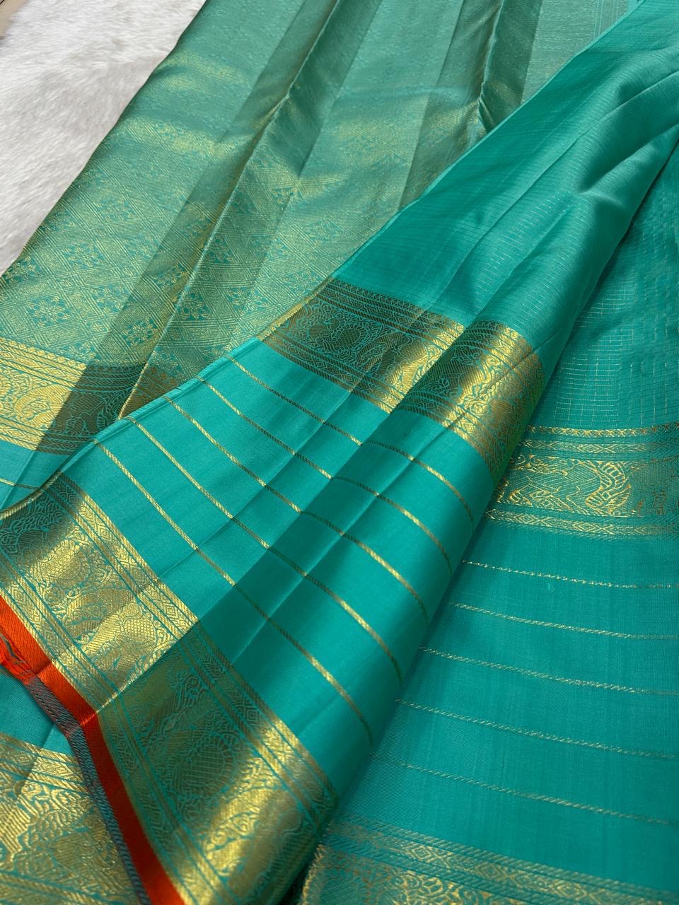 Close view of traditional antique-gold zari motifs woven on Sea Green Kanjivaram silk.