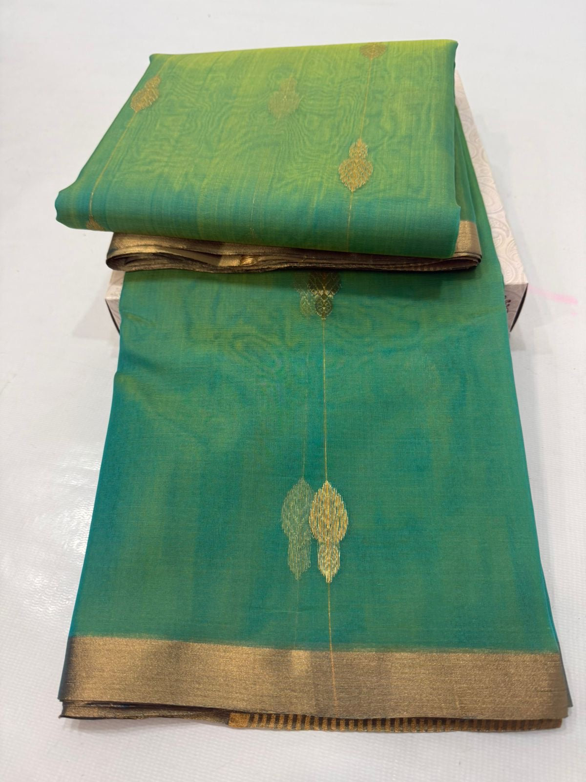 Folded Sea Green Katan Silk Chanderi saree showing gold woven buttas and fine antique-gold border