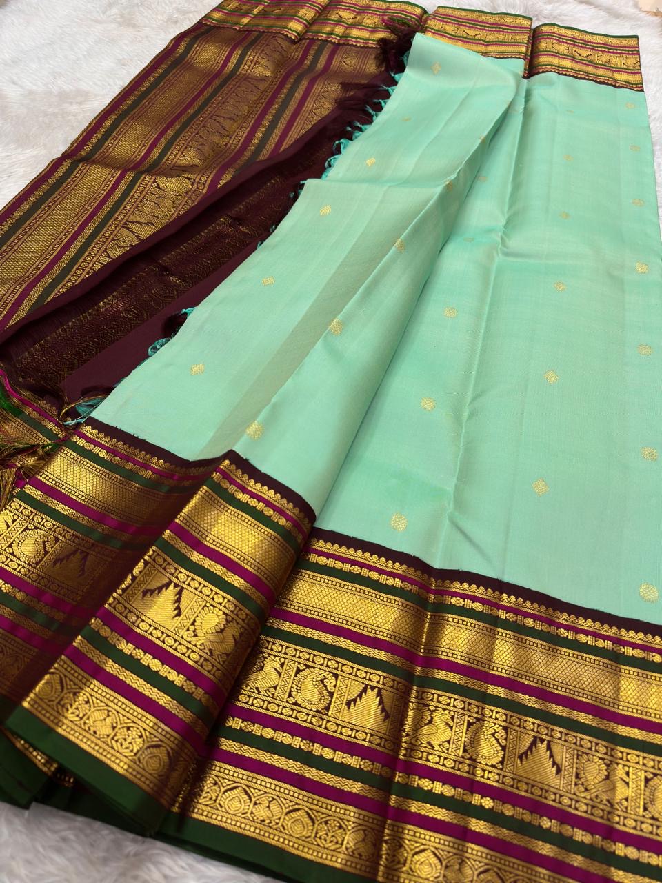 Close-up of seafoam green silk body with scattered gold zari coin butta motifs