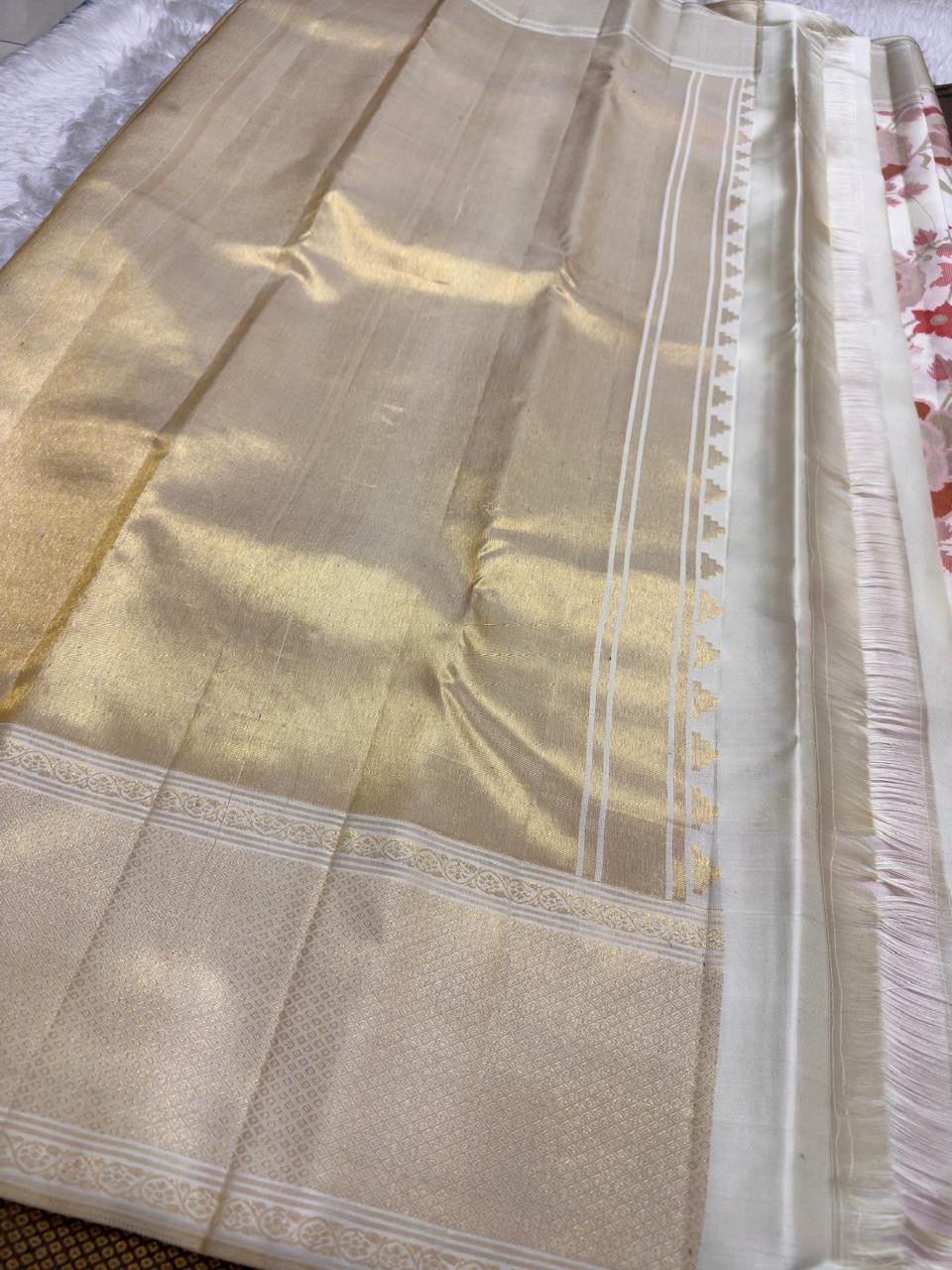 Handwoven ivory Butta saree with intricate floral jaal and soft antique-gold border.