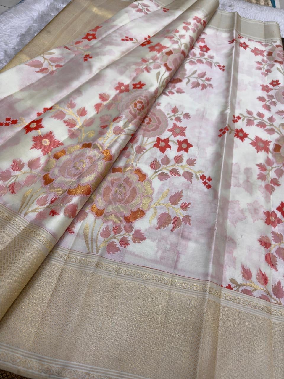 Ivory Kanchi Pattu saree with dusty rose coral sage and antique-gold handwoven floral motifs.