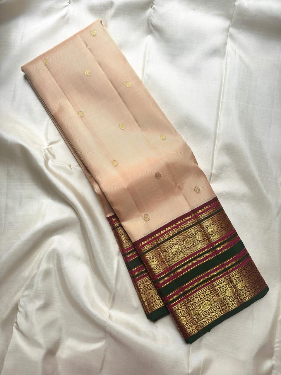 Deep maroon gold zari pallu with geometric lattice and repeated ornamental woven rows.