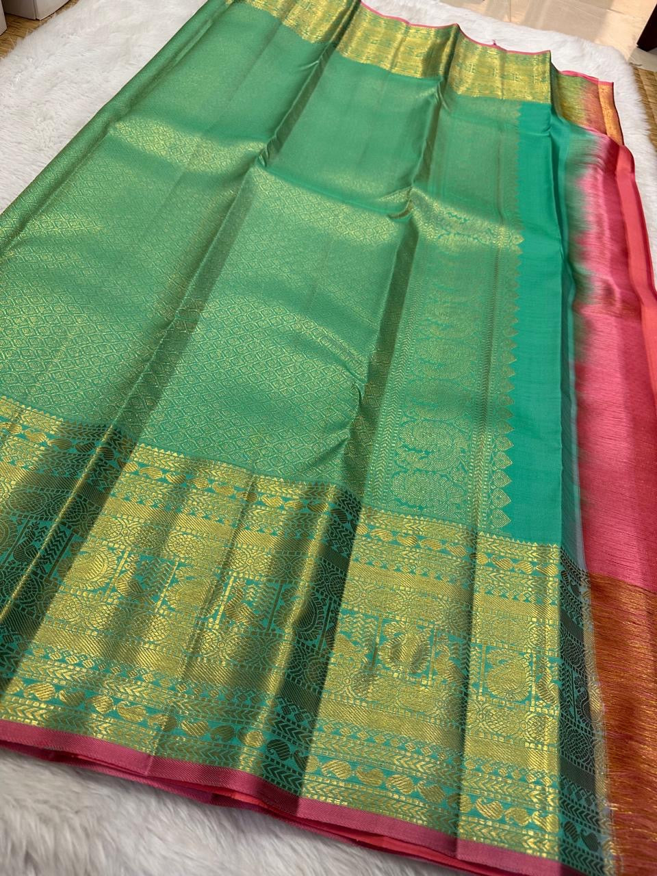 Raspberry-pink selvedge detail on aqua Kanchi Pattu Butta saree border