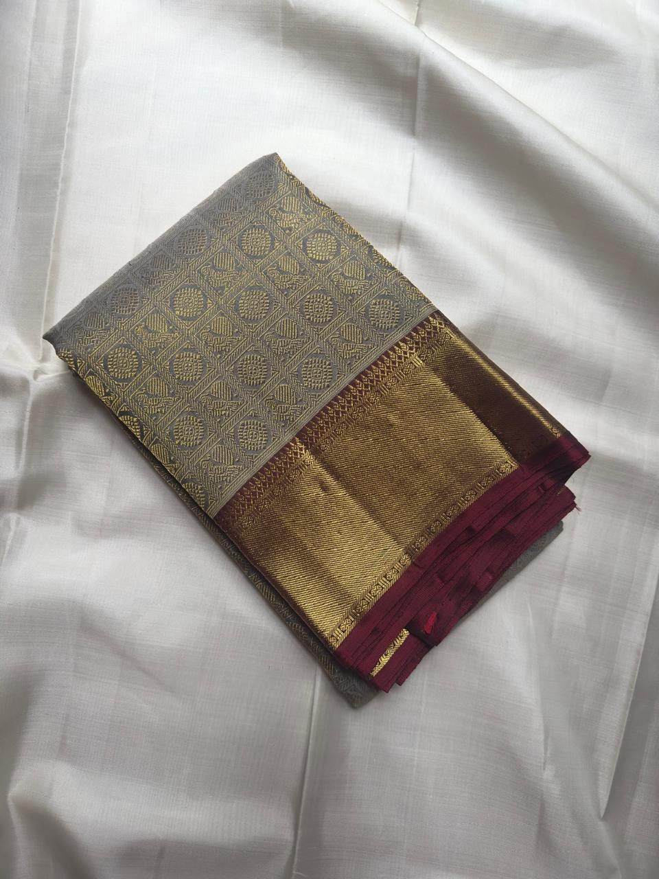 Silver Grey and Arakku Red Korvai Kanjeevaram saree with rich gold zari.