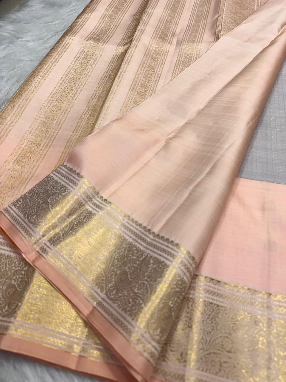Silver Grey Kanchipuram silk saree with Soft Peach Pink contrast and traditional zari buttas.