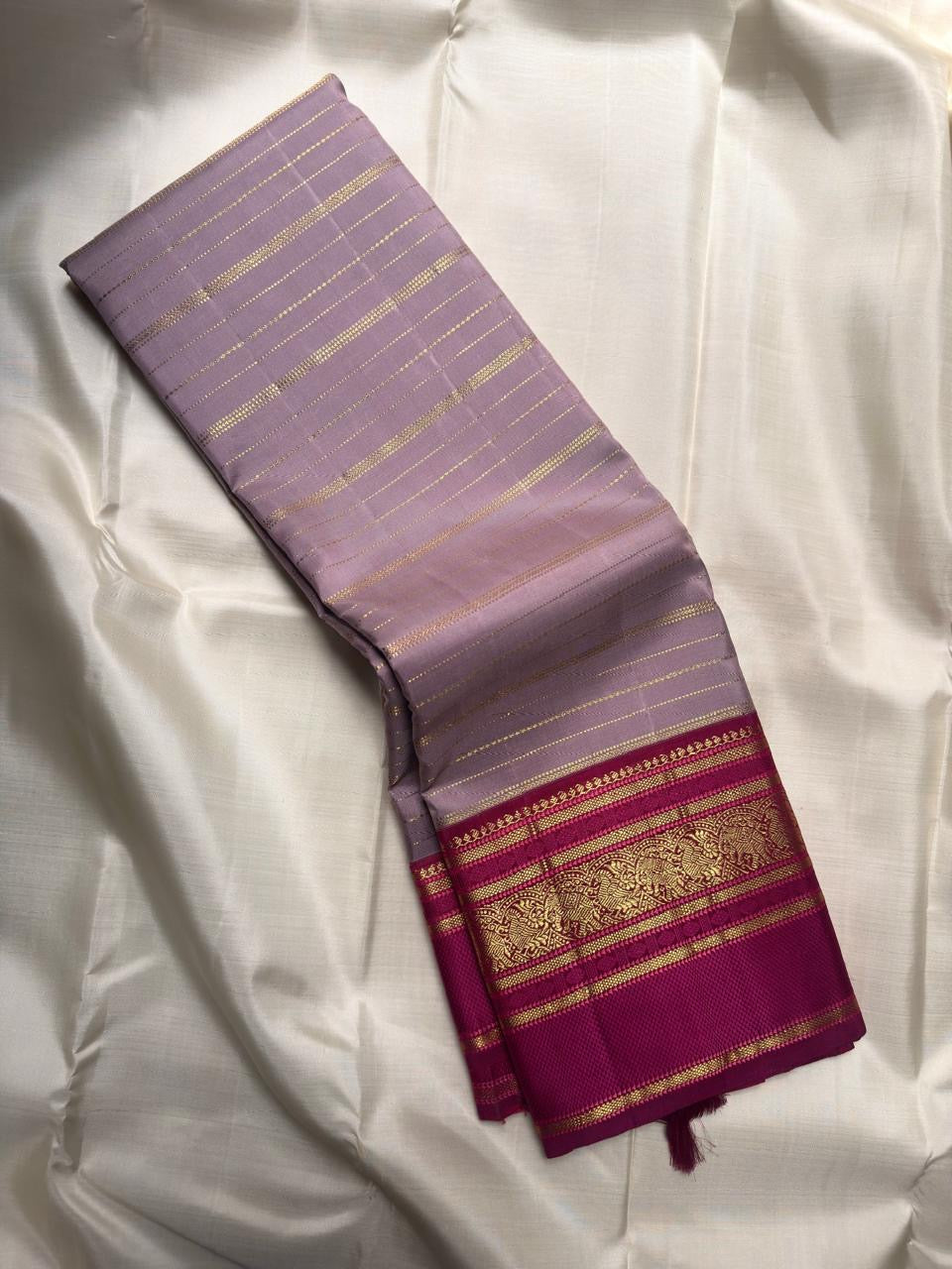 Silver lilac Kancheepuram silk saree with dense gold zari pallu framed in magenta