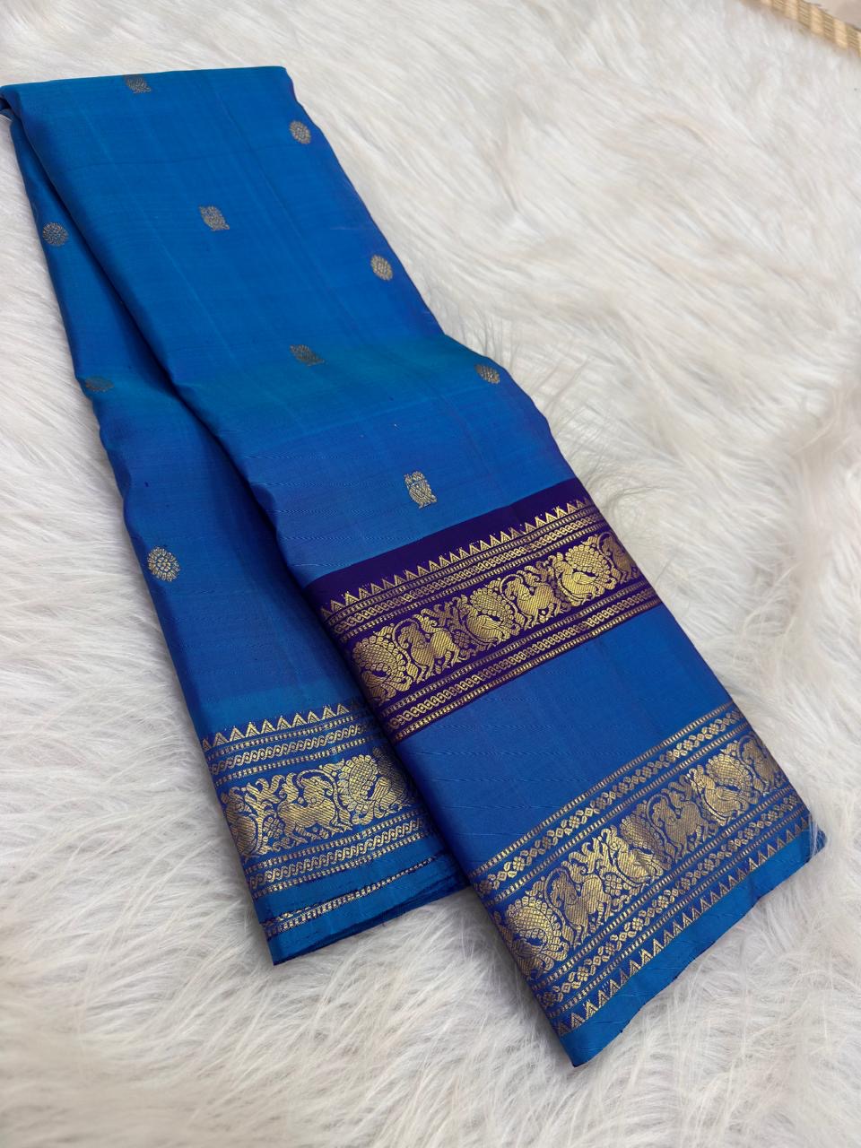 Silver zari buttas on the royal azure blue Kanjivaram Rettapet saree body