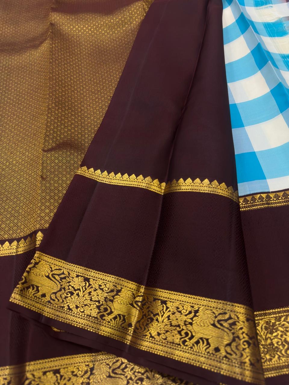 Deep-brown peacock and Kodi Malar zari border on a sky blue and ivory Kanchipuram saree.