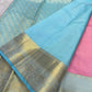 Sky blue pure Kanchipuram silk saree with gold zari woven pallu and sky blue border, pink fabric visible at the side, available in the USA