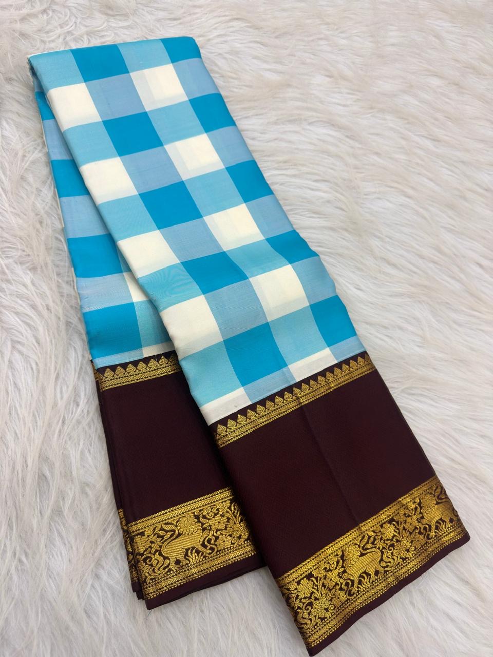 Sky blue Kanjivaram Paalum Pazhamum saree with a deep-brown peacock border.