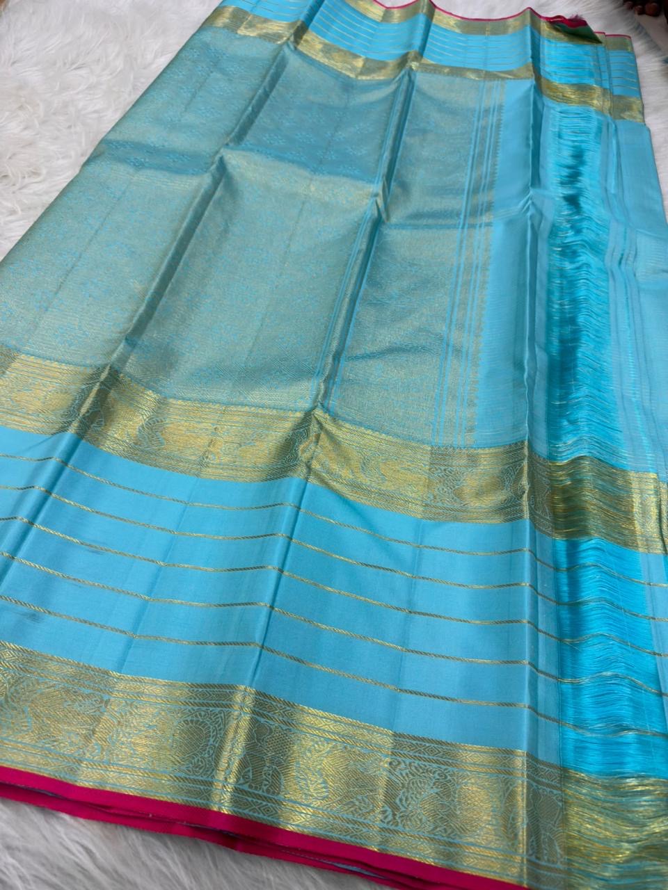Close view of antique-gold traditional zari motifs woven against Sky Blue Kanjivaram silk.