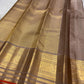 Taupe Kanchi Pattu silk saree with spaced handwoven zari buttas and rich gold border.