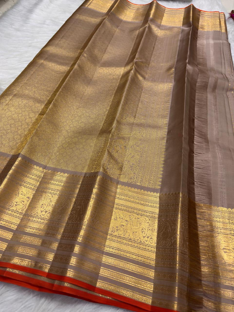 Taupe Kanchi Pattu silk saree with spaced handwoven zari buttas and rich gold border.