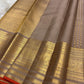 Smoky Taupe pure silk Kanchipuram Butta saree with antique-gold zari border and Burnt Orange selvedge.